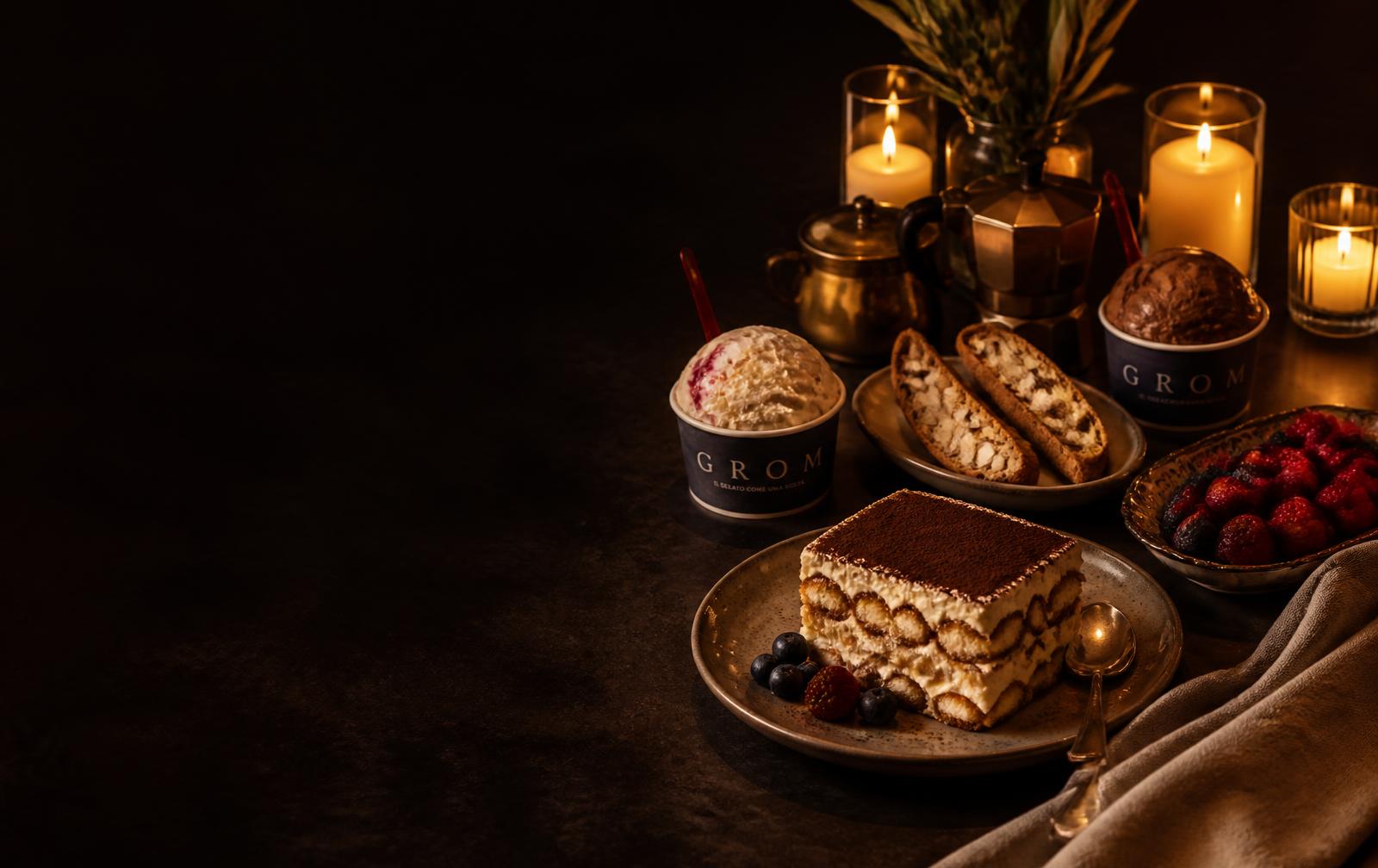 Candlelit dessert course — tiramisu, gelato, biscotti and berries on a dark table